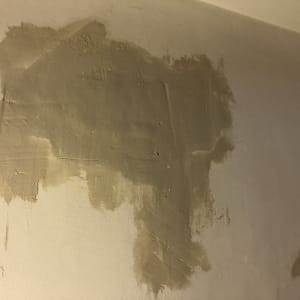 קיר עם טיח חלקי בתהליך תיקון