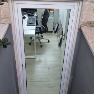 דלת אלומיניום עם מסגרת לבנה וחלון זכוכית