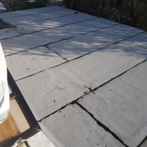 גג אטום ביריעות ביטומניות אפורות עם חיבורים שחורים