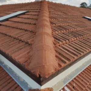 רעפים חומים על גג עם צינור מים