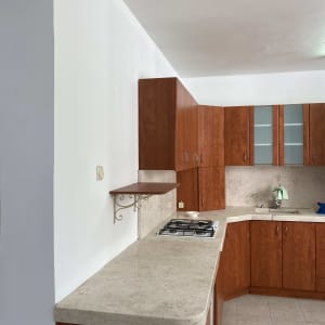 מטבח עם ארונות עץ ומשטח עבודה בהיר