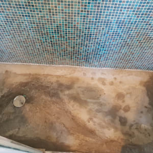 רצפת מקלחת עם אריחים מוסרים בתהליך שיפוץ