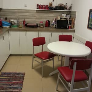 מטבח עם שולחן עגול וכיסאות מרופדים באדום