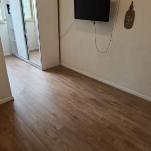 רצפת פרקט עץ חום בחדר עם קירות לבנים