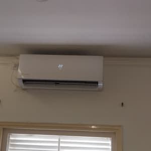 מזגן מותקן על קיר עם תצוגת טמפרטורה 22 מעלות