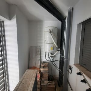 דוד מים מותקן על קיר עם צינורות מחוברים