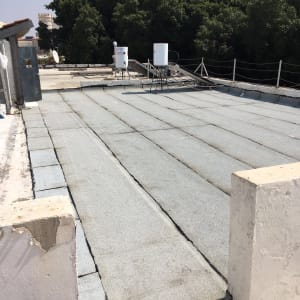 גג עם יריעות איטום אפורות ומיכלי מים