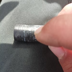 אדם מחזיק צינור מתכת קטן עם חריצים