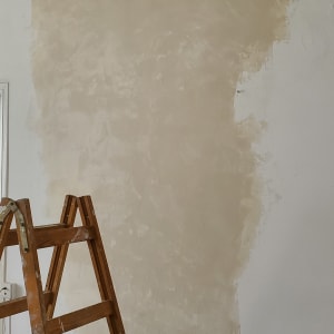 סולם עץ ליד קיר עם טיח טרי