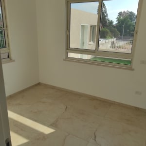 חדר ריק עם רצפת אריחים נקייה וחלונות פתוחים