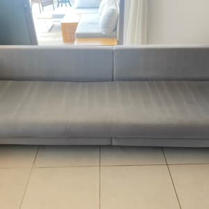 ספה אפורה נקייה על רצפת אריחים בהירה