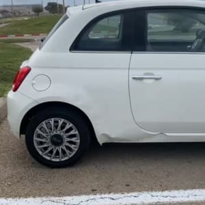 מכונית לבנה עם פגמים בצד האחורי