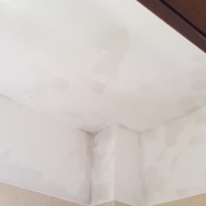 תקרה צבועה בלבן עם תיקוני צבע נראים