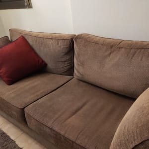 ספה חומה עם כרית אדומה על המושב