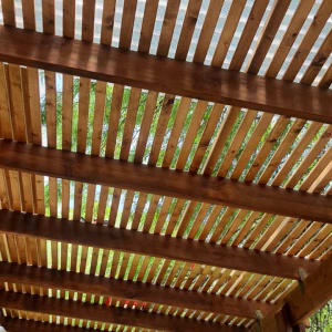 פרגולה מעץ עם קורות עץ וצלחת פלסטיק שקופה