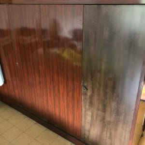 ארון עץ עם דלתות כהות וידית שבורה