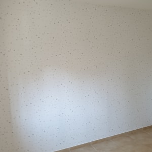 קיר עם טפט כוכבים קטנים על רקע לבן