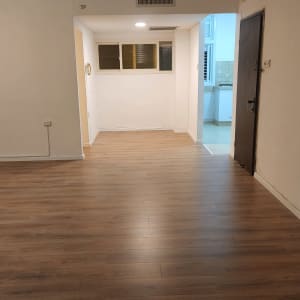 רצפת פרקט עץ בחדר ריק עם קירות לבנים