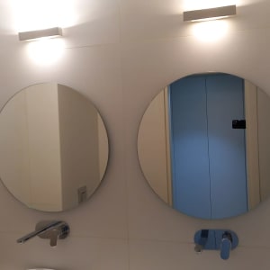 שתי מראות עגולות תלויות על קיר לבן