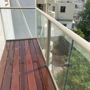 מרפסת עץ עם מעקה זכוכית שקופה