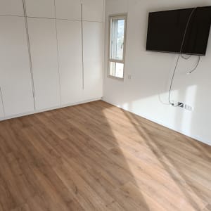 רצפת פרקט עץ בחדר עם קירות לבנים