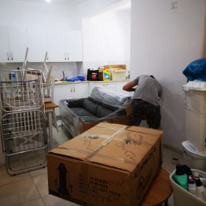 אדם אורז ספה וקרטונים למעבר דירה