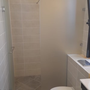 דלת זכוכית חלבית במקלחת עם ידית מתכת