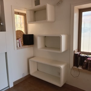 מדפים לבנים מותקנים על קיר ליד חלון