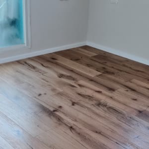 רצפת פרקט עץ בחדר עם קיר לבן