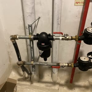 צינורות מים עם ברזים ומדי מים בחדר שירות