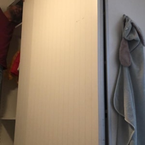 אדם מתקין דלת ארון לבנה בחדר