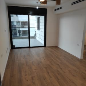 רצפה נקייה מעץ ליד חלון זכוכית גדול