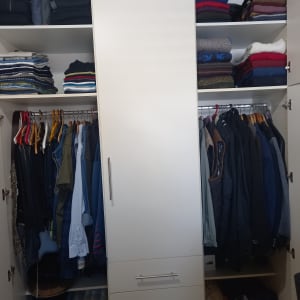 ארון בגדים מאורגן עם בגדים מקופלים ותלויים