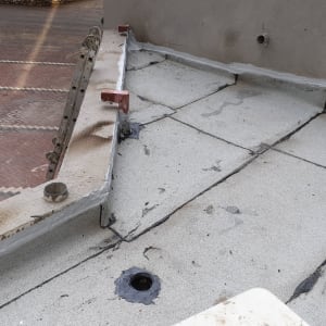 גג אטום עם יריעות ביטומניות וחומרי איטום סביב צינור