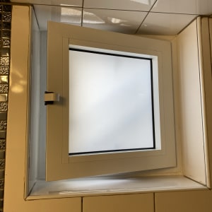 חלון אלומיניום פתוח עם מסגרת לבנה