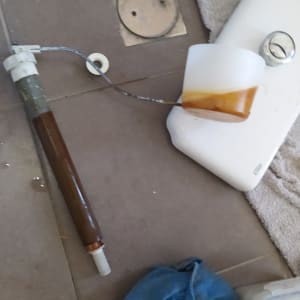 חלקי אסלה מפורקים על רצפה עם כלי עבודה