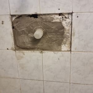 קיר אריחים עם תיקון בטיח וחור חשוף