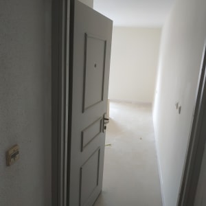 דלת פתוחה לחדר עם קירות צבועים בלבן