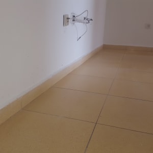 קיר לבן עם שקעי חשמל וכבלים חשופים