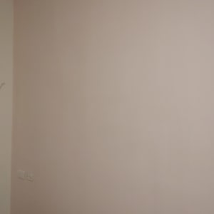 קיר צבוע בצבע בהיר עם שקע חשמל