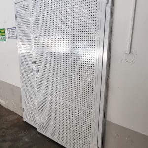 דלת מתכת מחוררת עם מסגרת לבנה