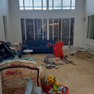 צעצועים וספרים מפוזרים על רצפת סלון