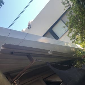 גג מתכת עם קורות תומכות ועצים מסביב