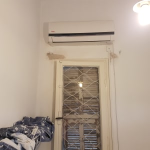 קיר צבוע עם כתמי צבע, חלון עם תריסים ישנים