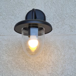 מנורת קיר דולקת עם כיסוי זכוכית על קיר