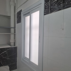 חלון חדש עם מסגרת לבנה על קיר משופץ