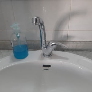 ברז כרום מותקן בכיור לבן עם סבון נוזלי כחול