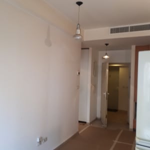 קיר צבוע בלבן עם נורות תלויות מהתקרה