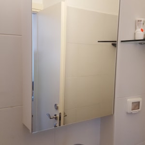 מראה על קיר עם מדף זכוכית