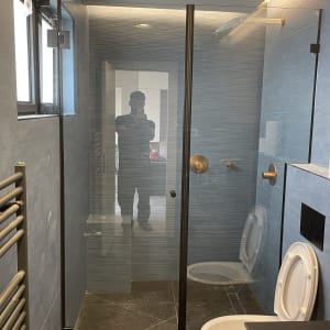 מקלחון זכוכית עם דלתות שקופות וברז זהב